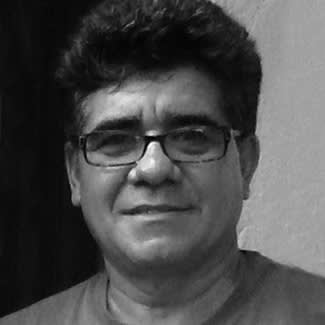 Black and white photograph of a man looking directly at the camera. He is cleanly-shaven with a round face and wears squarish glasses.