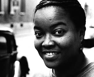 Black and white photograph of a woman smiling and looking directly at the camera.