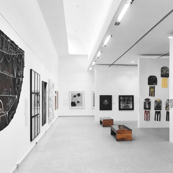 Installation shot of exhibition. It shows many of the works from the collection mounted on the walls of a museum space.